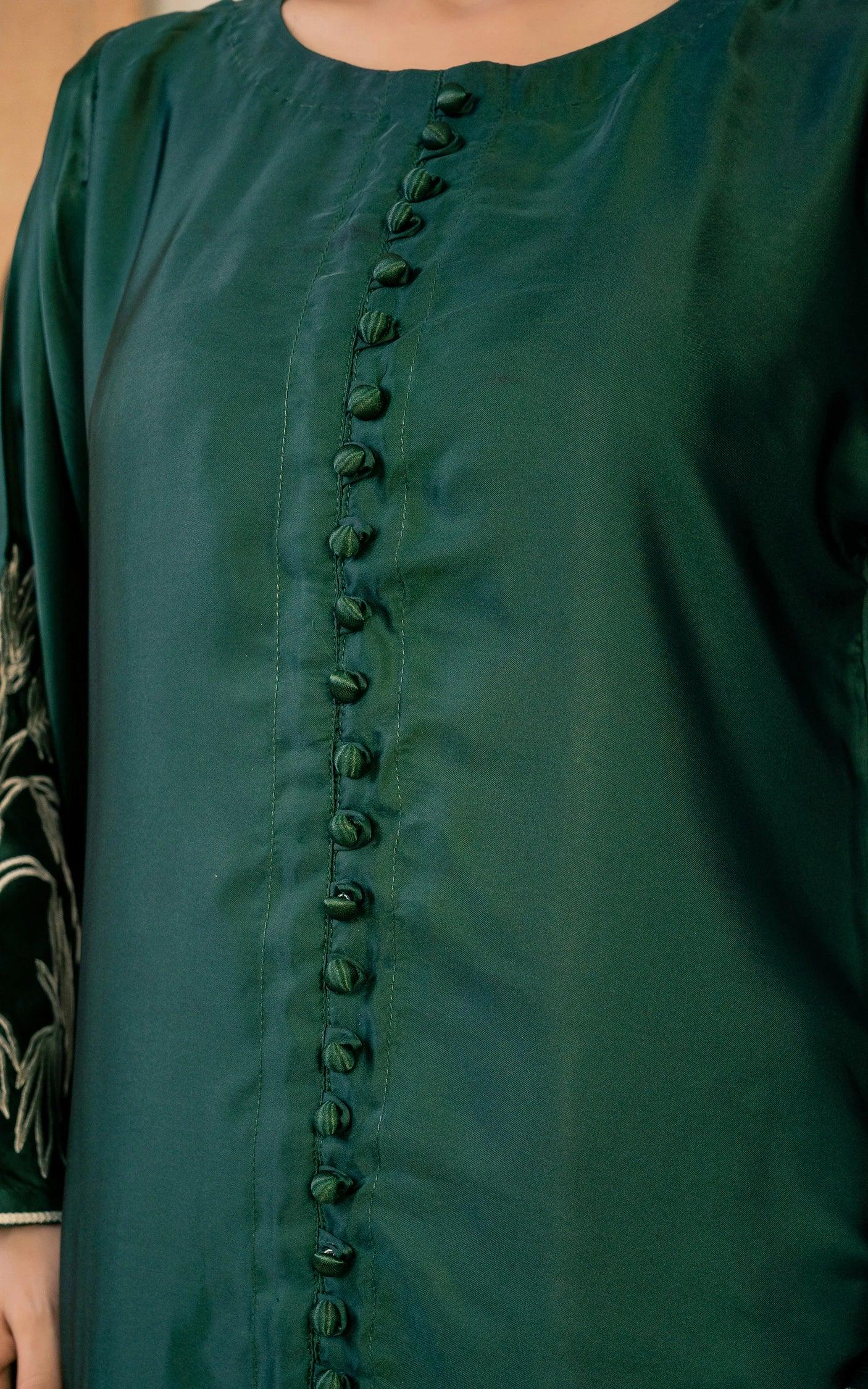 Green dress with button details on a plain background